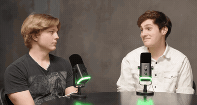 Two Men Sitting At Table With Microphones GIF