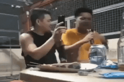 Two Men Sitting At Table With Soda And Food GIF