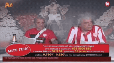 Two Men Sitting In Front Of Ante Geia Sign GIF