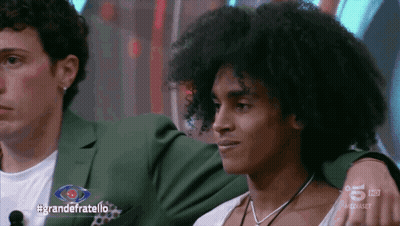 Two Men Sitting In Front Of #GrandeFratello Screen GIF