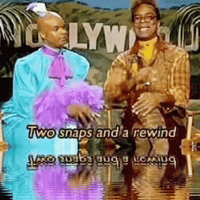 Two Men Sitting In Front Of Hollywood Sign GIF