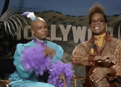 Two Men Sitting In Front Of Hollywood Sign GIF