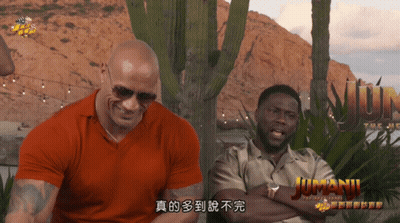 Two Men Sitting In Front Of Jumanji Sign GIF