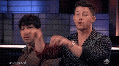 Two Men Sitting In Front Of Songland Screen GIF