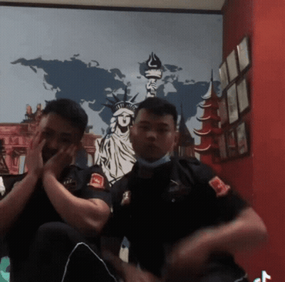 Two Men Sitting In Front Of World Map GIF