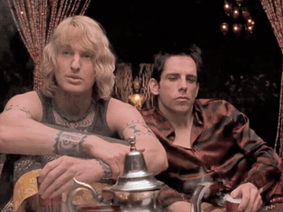 Two Men Sitting Next To Each Other One With Tattoo Saying A GIF