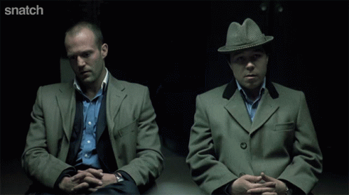 Two Men Sitting Next To Each Other With Snatch Written On The Bottom Right GIF