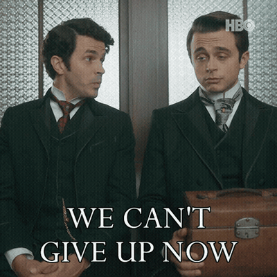 Two Men Sitting Next To Each Other With The Words We Can 'T Give Up Now Behind Them GIF