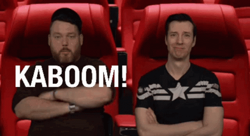Two Men Sitting Next To Each Other With Their Arms Crossed And The Words Kaboom On The Bottom Right GIF