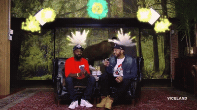 Two Men Sitting On A Couch In Front Of A Wall With The Word Viceland On It GIF