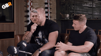Two Men Sitting On A Couch With Gbr Written On The Corner GIF