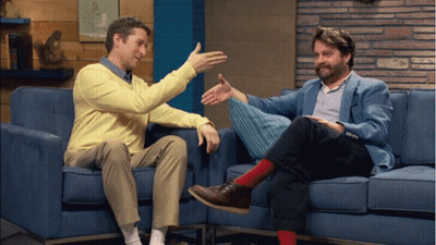 Two Men Sitting On Blue Couch Talking GIF