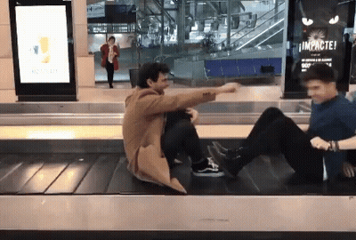 Two Men Sitting On Conveyor Belt Saying Impactei GIF