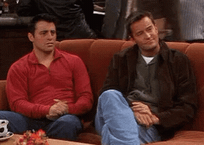 Two Men Sitting On Couch One In Red Sweater GIF