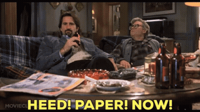 Two Men Sitting On Couch Saying Heed Paper Now GIF