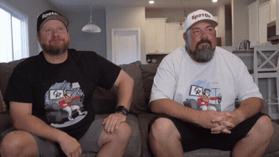 Two Men Sitting On Couch Wearing Spoton Shirts GIF