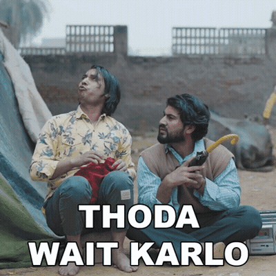 Two Men Sitting On Ground Thoda Wait Karlo GIF