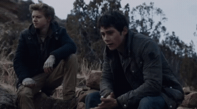 Two Men Sitting On Rocky Hillside Talking GIF