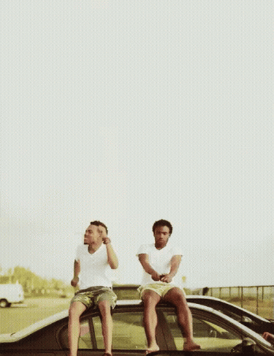 Two Men Sitting On The Roof Of A Car Drinking Beer GIF