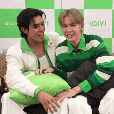 Two Men Sitting One Holding Green Pillow GIF