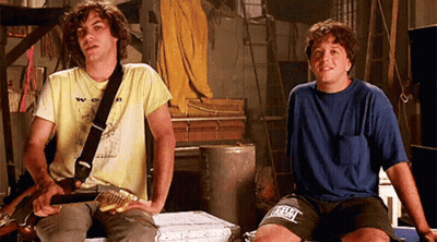 Two Men Sitting One Holding Guitar Other Wearing Everlast Shirt GIF