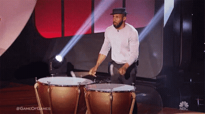 Two Men Sitting, One In Black Puma Shirt GIF