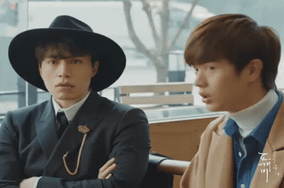 Two Men Sitting One In Hat GIF