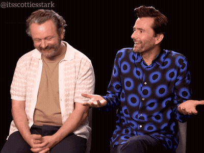 Two Men Sitting One With Circle Shirt GIF