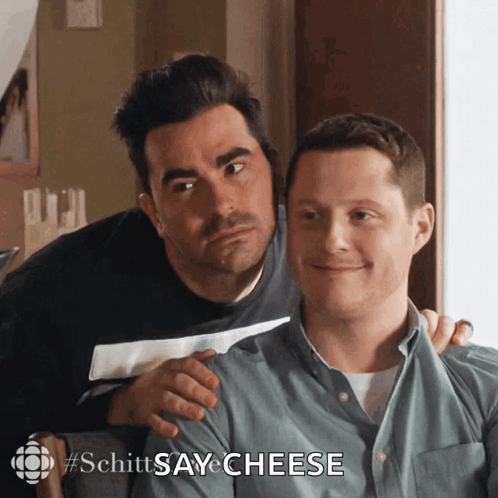 Two Men Sitting With Schitts Say Cheese GIF