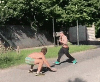 Two Men Squatting Side Of Road GIF