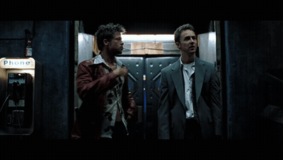 Two Men Stand In Front Of A Phone Booth That Says Phone GIF