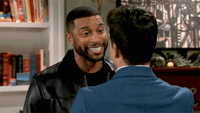 Two Men Standing And Smiling At Each Other GIF