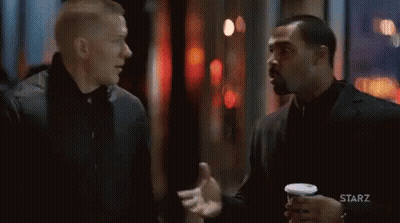 Two Men Standing And Talking In Dark Room GIF