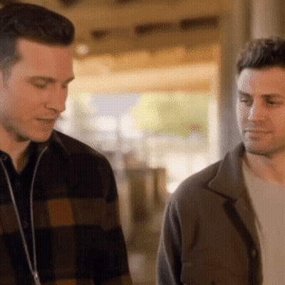 Two Men Standing And Talking In Room GIF