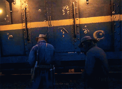 Two Men Standing Before Bullet-Hole Train Saying Target The Fuck GIF