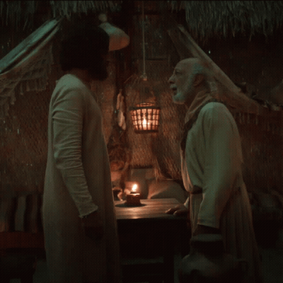 Two Men Standing Beside Candle In Dark Room GIF