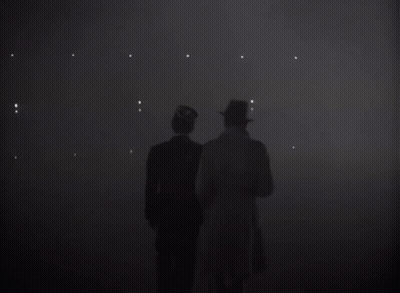 Two Men Standing In A Dark Room With The Word Louis On The Bottom GIF