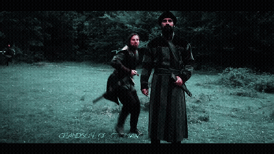 Two Men Standing In A Field With The Words Grandson Of Otoman On The Bottom Right GIF