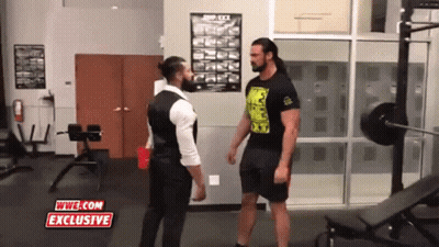 Two Men Standing In A Gym With Wwe.com Exclusive Written On The Screen GIF