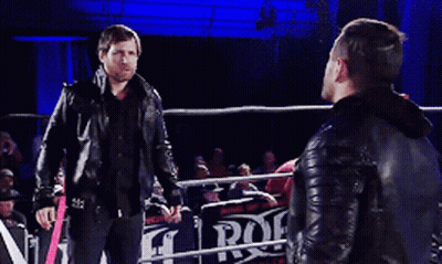 Two Men Standing In A Wrestling Ring With A Sign That Says Rock GIF