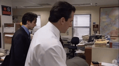 Two Men Standing In An Office With A No Smoking Sign On The Wall GIF