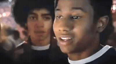 Two Men Standing In Crowd One With Afro GIF
