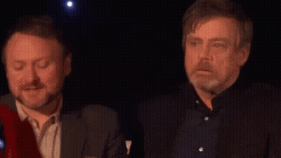 Two Men Standing In Dark Room Looking At Something GIF