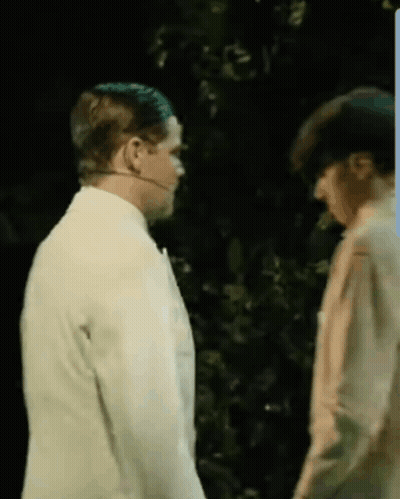 Two Men Standing In Dark Room With Trees GIF