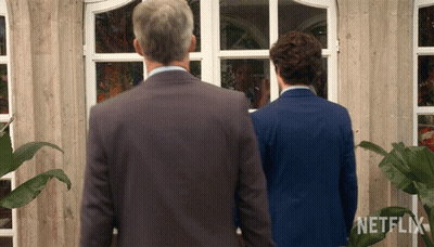 Two Men Standing In Front Of A Building With A Netflix Logo On The Bottom GIF
