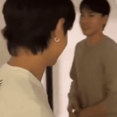 Two Men Standing In Front Of A Mirror, One Wearing Earrings GIF