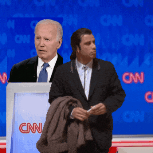 Two Men Standing In Front Of A Podium That Says Cnn On It GIF