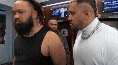 Two Men Standing In Front Of A Sign That Says Austin Monti GIF