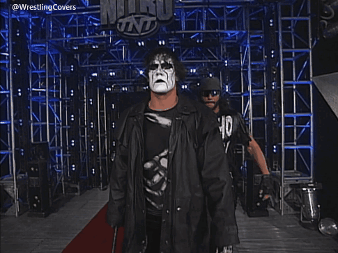 Two Men Standing In Front Of A Sign That Says Wcw Monday Nitro GIF