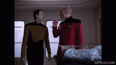 Two Men Standing In Front Of Baby In Crib GIF